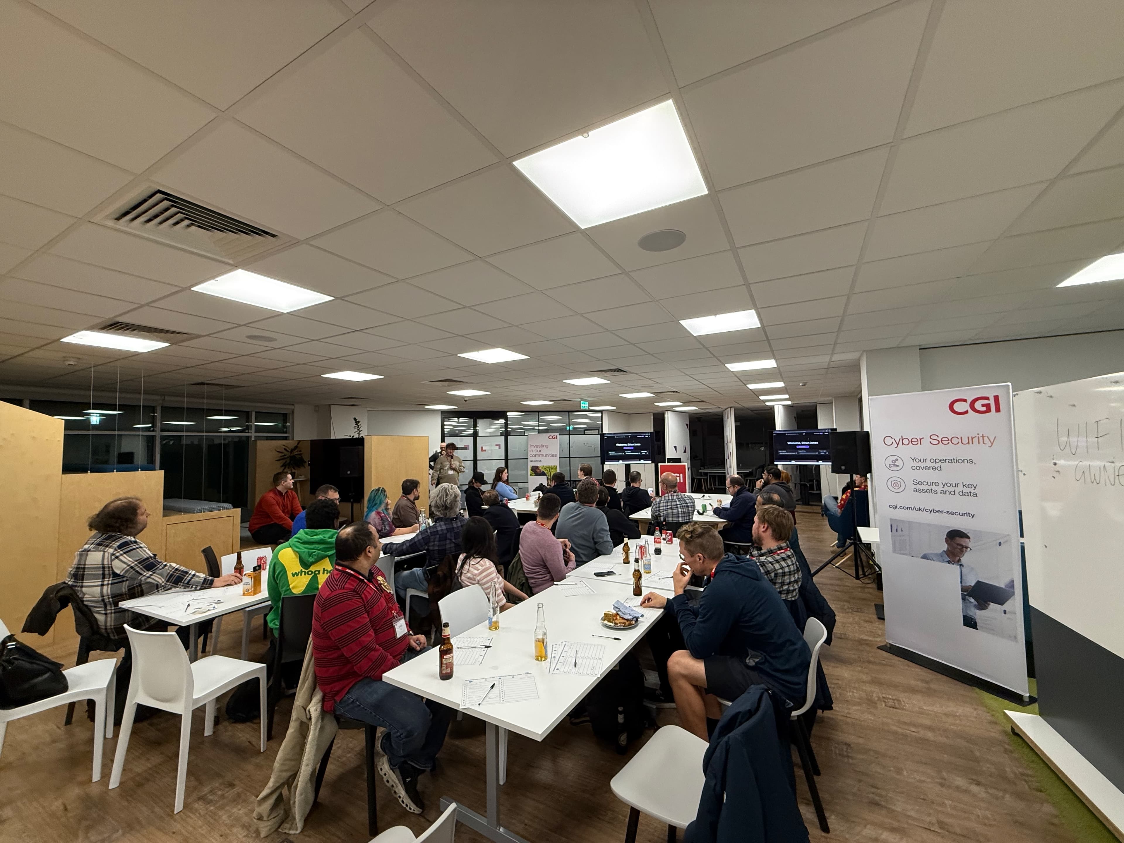 Evening community session around shared tables at a CGI venue