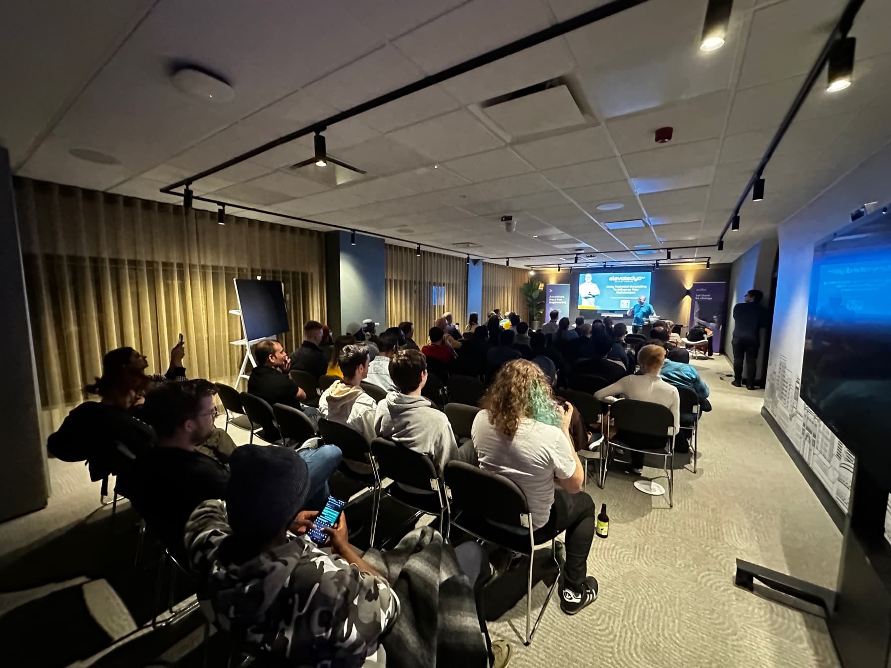 An evening meetup audience in a warmly lit room
