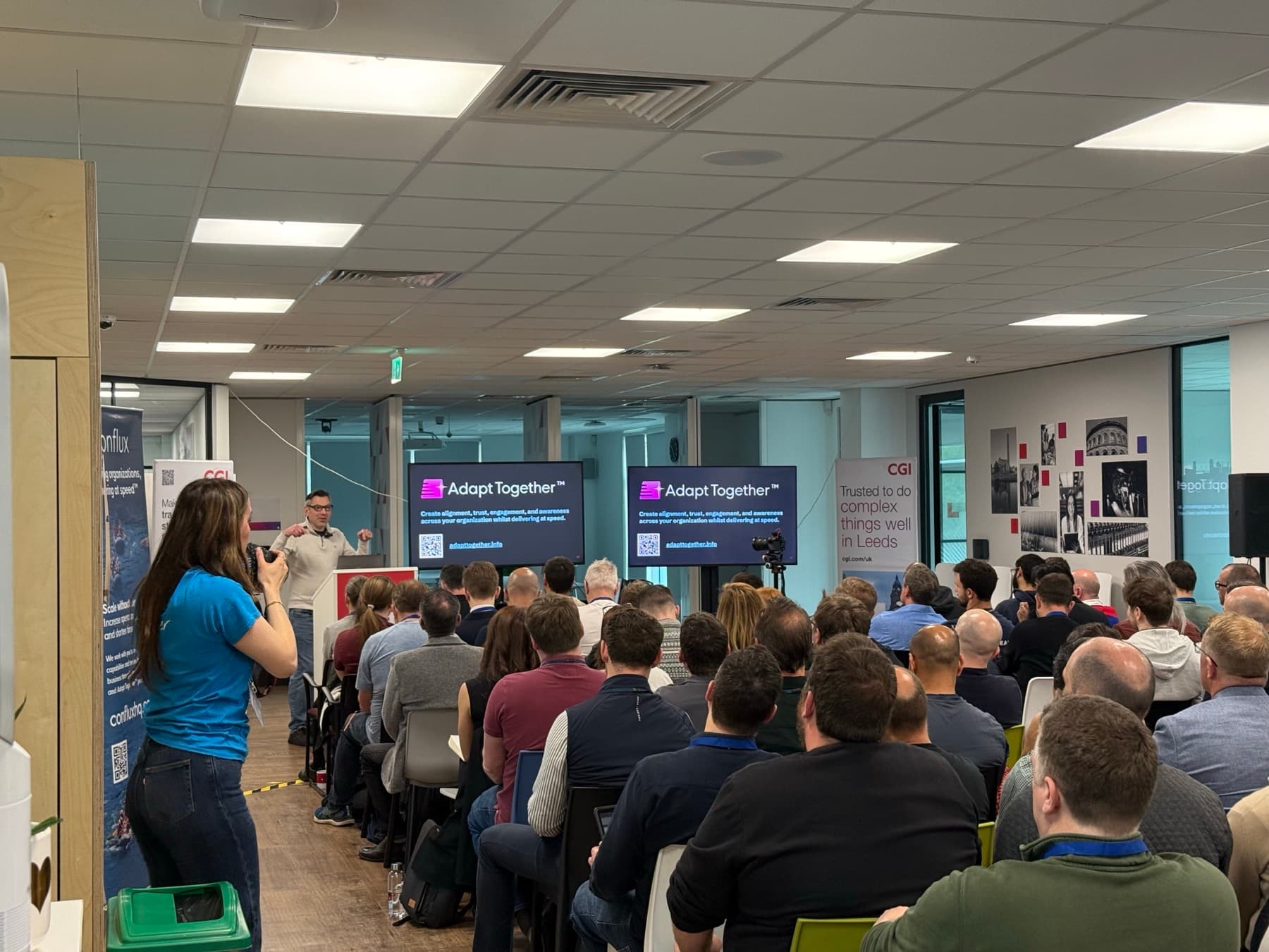 A speaker presenting to a packed office room