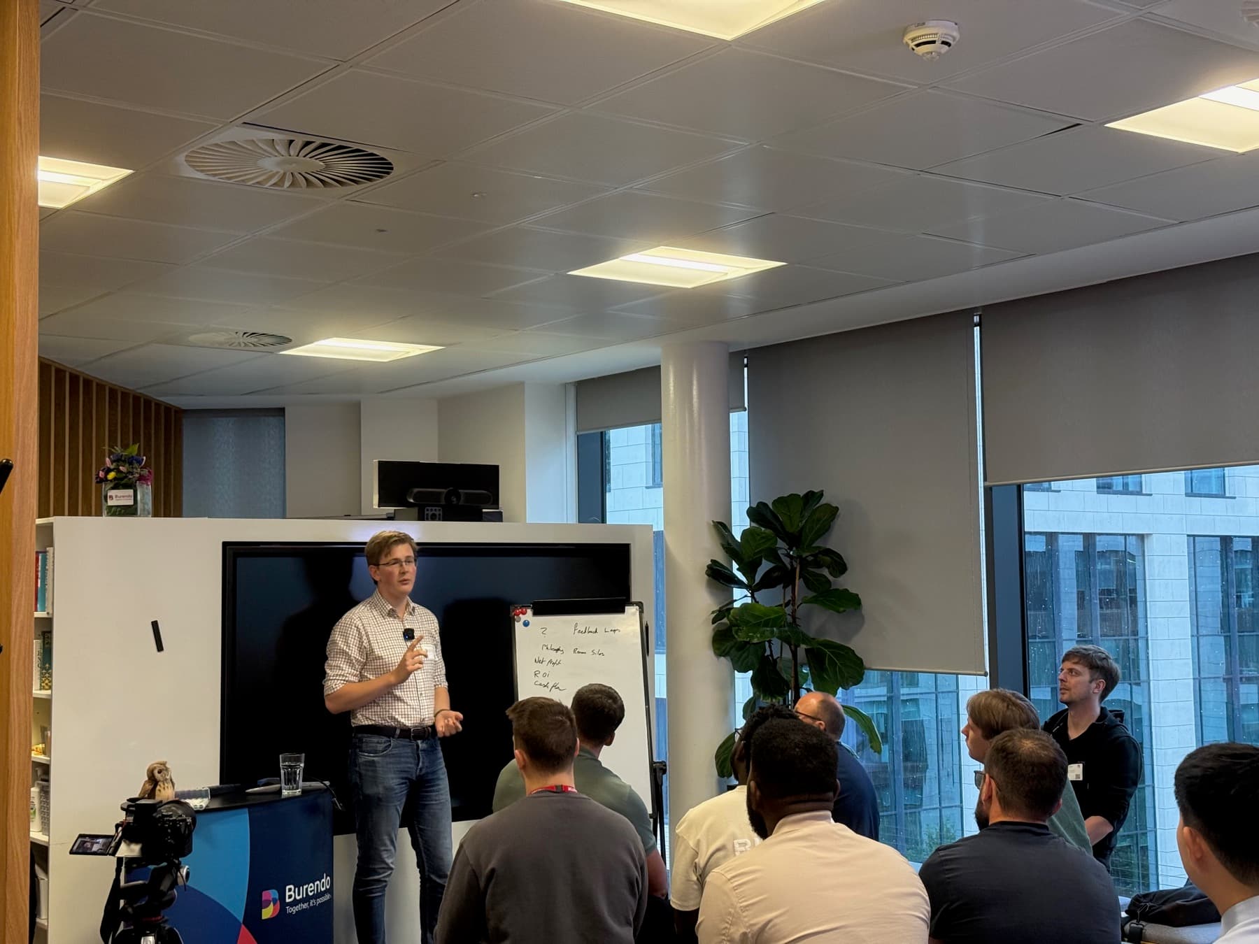 A speaker taking questions at a whiteboard