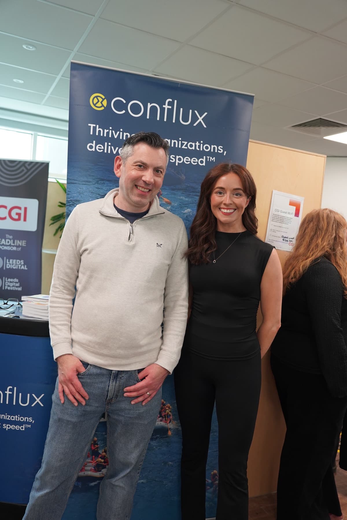Two attendees smiling at the CGI stand
