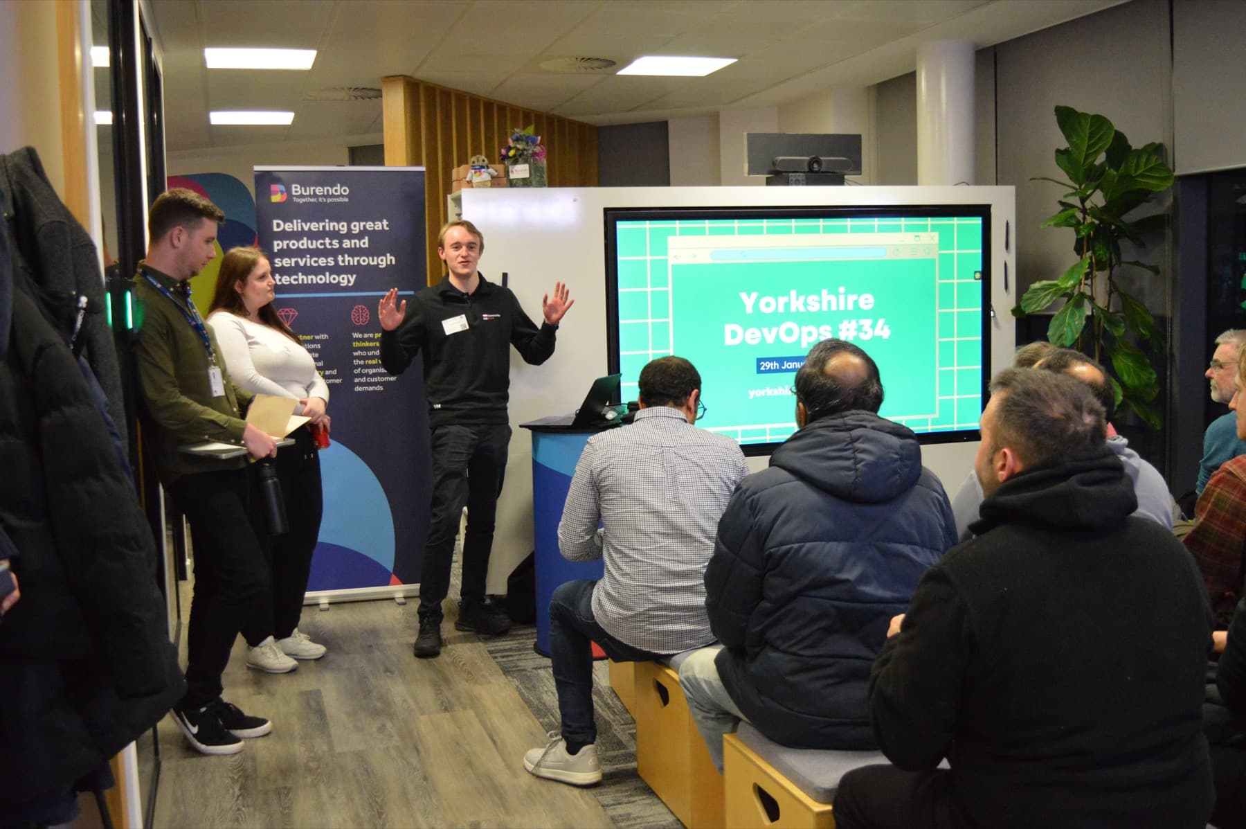 An organiser welcoming the room with the Yorkshire DevOps slide on screen